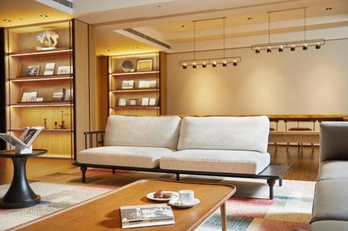 a living room with a couch and a table at MGH Mitsui Garden Hotel Taipei Zhongxiao in Taipei