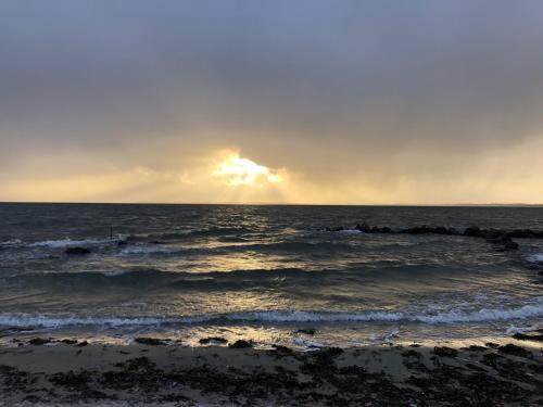 ein Sonnenuntergang über dem Meer mit Wellen in der Unterkunft Lynæs Hotel in Hundested