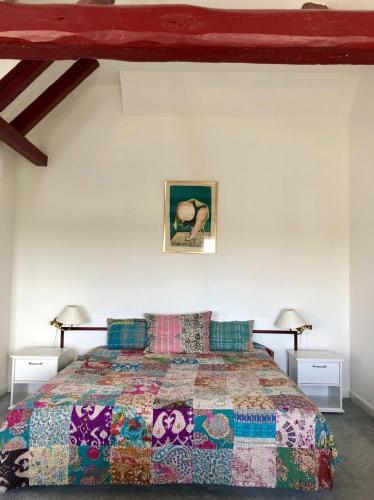 a bedroom with a bed with a colorful bedspread at Lynæs Hotel in Hundested