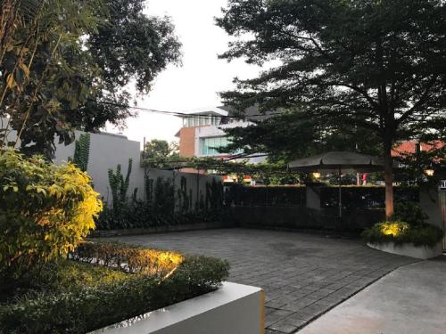a garden with a patio with an umbrella and trees at Home 899 Patal Senayan in Jakarta