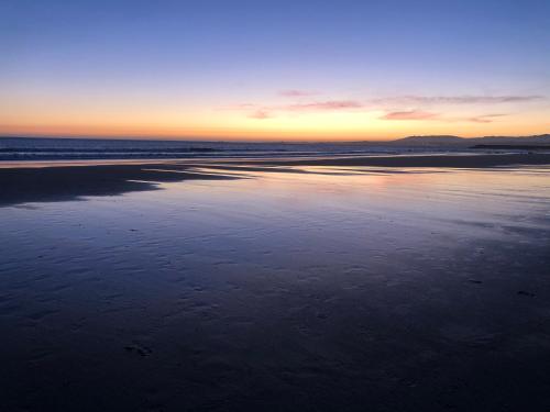 a view of the beach at sunset at Apartment Qiu lux costa da caparica in Costa da Caparica