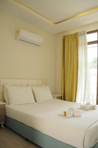 a bedroom with a bed with white sheets and a window at Kemer Suites in Kemer