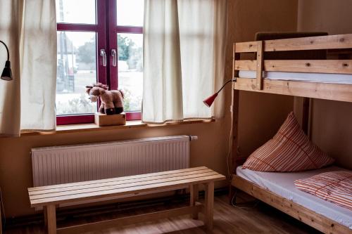 a bedroom with two bunk beds and a window at Südhof Döbbrick - Ferienhof für Familienurlaub in Cottbus