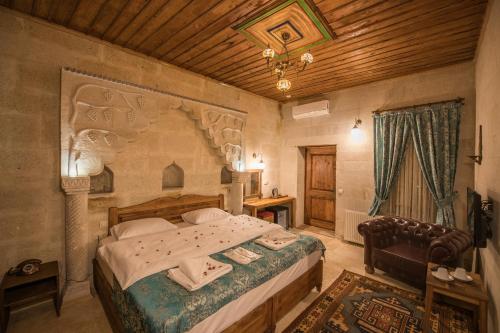 a bedroom with a large bed and a wooden ceiling at Charming Cave Hotel in Göreme