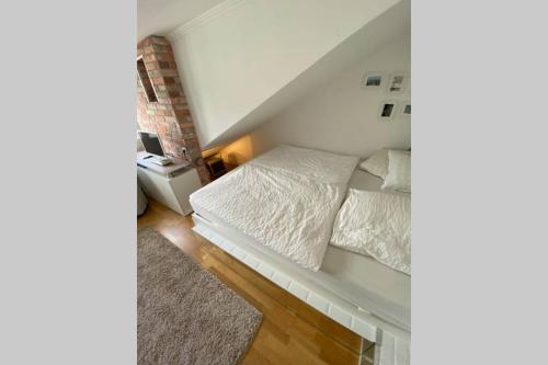 - une chambre dotée d'un lit avec des draps blancs dans l'établissement DG Wohnung mit separatem Eingang nahe Düsseldorf, à Meerbusch