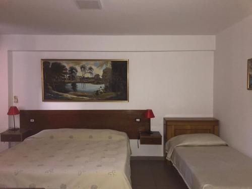 a bedroom with two beds and a painting on the wall at Hotel Lido in Durrës