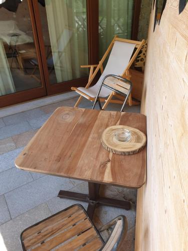 a wooden table and a chair on a patio at MH Olen Boutique Hotel in Alagna Valsesia