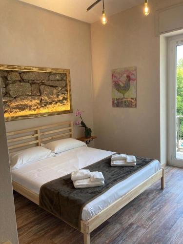a bedroom with a large bed with two pillows on it at Locanda Il Gallo in Baveno