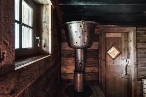 a bucket in the corner of a room with a door at Hotel Chalet Corso in San Vigilio Di Marebbe
