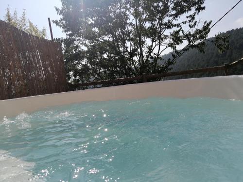 una piscina de agua azul frente a una valla en Cal Teixidor - La Fusteria en Salo
