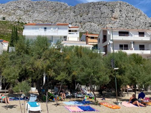 a group of people on a beach with a building at Apartment Anastazija in Omiš