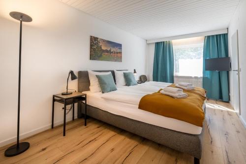 a bedroom with a large bed with blue curtains at Hotel Clement - Bed & Breakfast in Ingelheim am Rhein