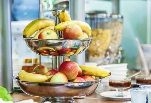 two baskets of apples and bananas on a table at Lira Pacific Aparthotel in Constanţa