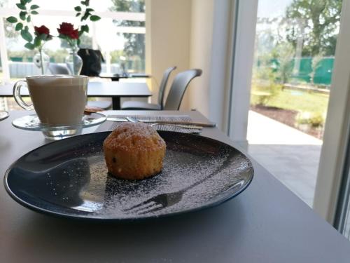 a muffin sitting on a black plate on a table at Il Rifugio Del Tempo in Roccasecca