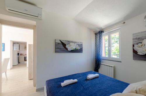 1 dormitorio con 1 cama azul y 2 toallas en CASA ROSA- Appartamento nel verde con posto auto, zona tranquilla,wifi gratuito,aria condizionata, en Rapallo