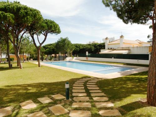 a swimming pool in a yard next to a house at Vila Falesia Penthouse in Albufeira