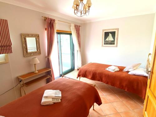 a hotel room with two beds and a window at Vila Falesia Penthouse in Albufeira