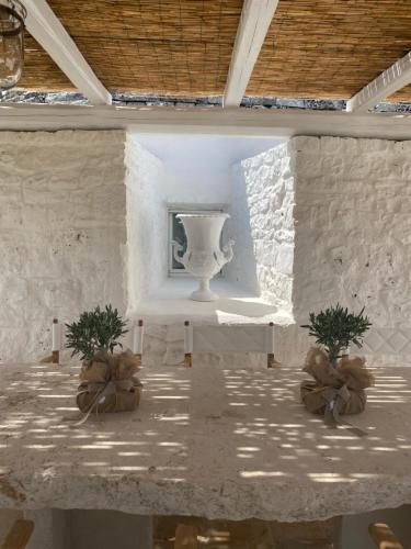 een kamer met een tafel met twee planten erop bij Borgo Fantese in Ostuni