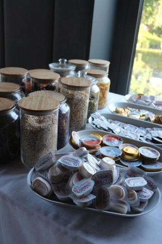 a table with a plate of food and jars of food at Regatta Hotel Restauracja Spa in Poznań