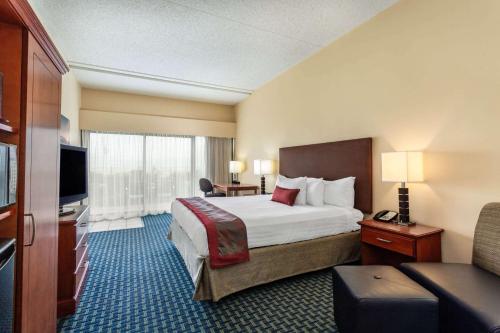 a hotel room with a bed and a television at Ramada Plaza by Wyndham Virginia Beach Oceanfront in Virginia Beach