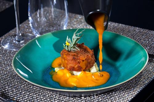 a plate of food with a piece of meat and orange sauce at Douro Palace Hotel Resort & SPA in Baião