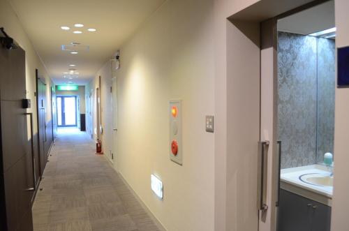 un corridoio di un ospedale con lavandino e specchio di My Hotel Ryugu a Shizuoka