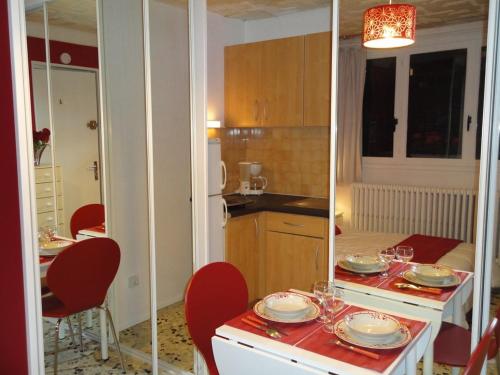 a kitchen with a table with plates and glasses on it at Studio Framboise proche Paris et Disneyland in Gagny