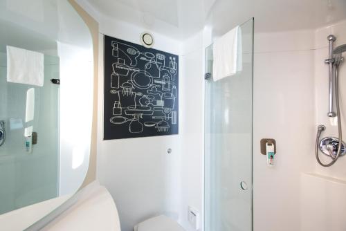 a bathroom with a shower and a black board on the wall at ibis Leicester in Leicester