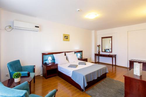 a hotel room with a bed and a chair at Lira Pacific Aparthotel in Constanţa
