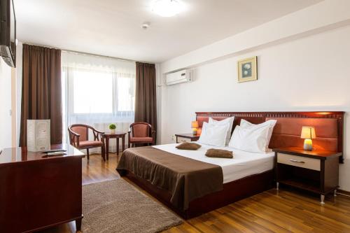 a hotel room with a bed and a table at Lira Pacific Aparthotel in Constanţa