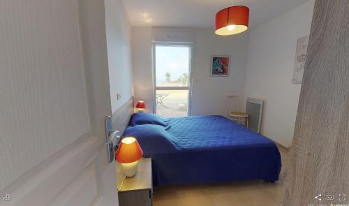 a bedroom with a blue bed and a window at Ty Koad in Lanmodez