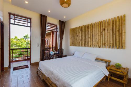 een slaapkamer met een wit bed en een groot raam bij MH Cherish Homestay in Ninh Binh