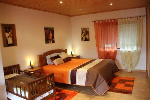 um quarto com uma cama grande e uma janela em Casa Nobre SERRA DA ESTRELA em Digueifel