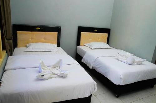 two beds with white masks on them in a room at Pondok Wisata dan Restoran Elim in Waingapu