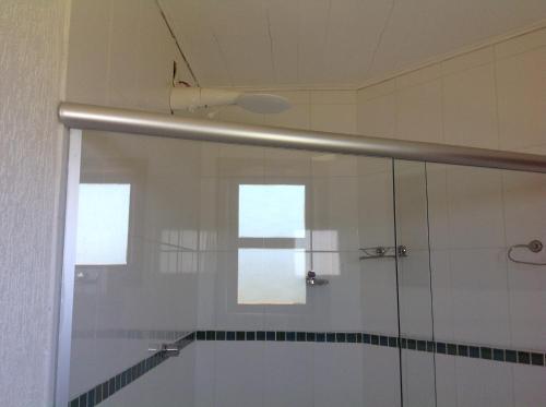 uma cabina de duche em vidro numa casa de banho com uma janela em Pousada Shamballa em Sao Jorge