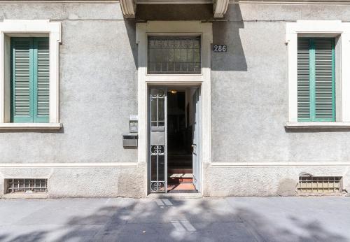 a door to a building with green shutters at Alessia's Flat - Certosa in Milan