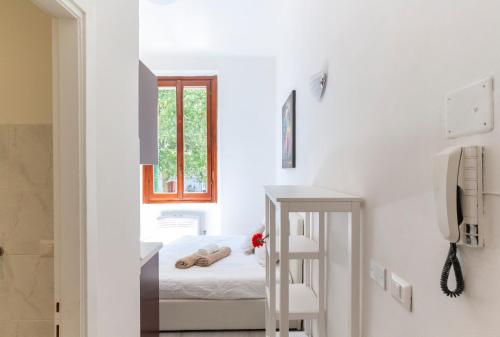 a white room with a bed and a window at Alessia's Flat - Certosa in Milan