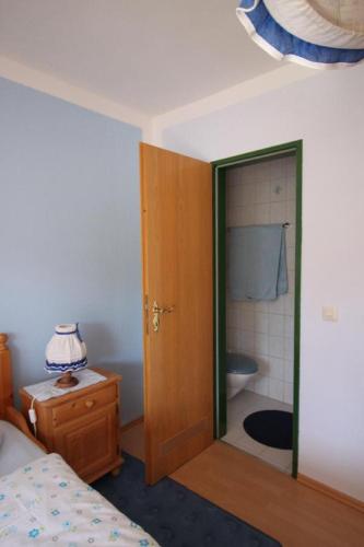 a bedroom with a bed and a bathroom with a toilet at Gästehaus Schreiner in Sankt Oswald