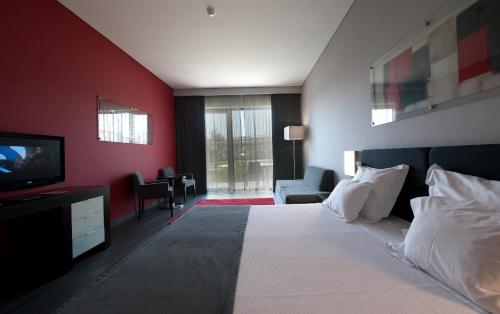 a hotel room with a bed and a television at Vila Gale Lagos in Lagos