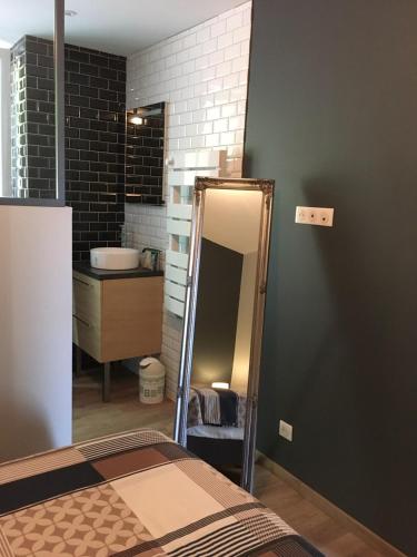 a bathroom with a mirror next to a bed at L'AUBERGADE Bis in Vittel