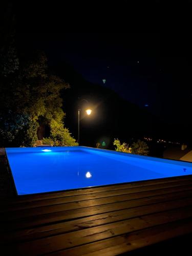 ein blauer Pool in der Nacht mit Straßenbeleuchtung in der Unterkunft L'Eyssart in Les Vigneaux