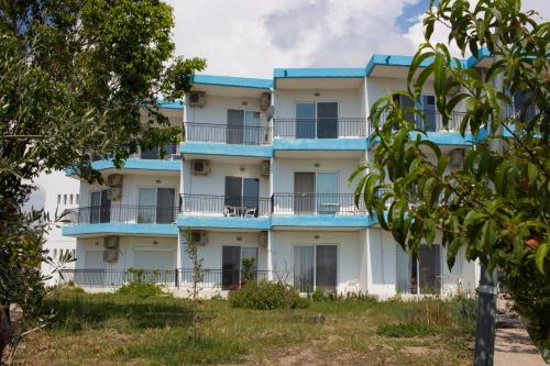 een appartementencomplex met blauwe balkons en bomen bij Planet View in Faliraki