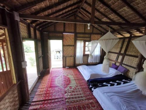 1 dormitorio con 2 camas en una habitación con ventanas en Wanmai Farm Stay Muangkong วันใหม่ฟาร์มสเตย์ เมืองคอง เชียงดาว, en Ban Yang Nong Bua