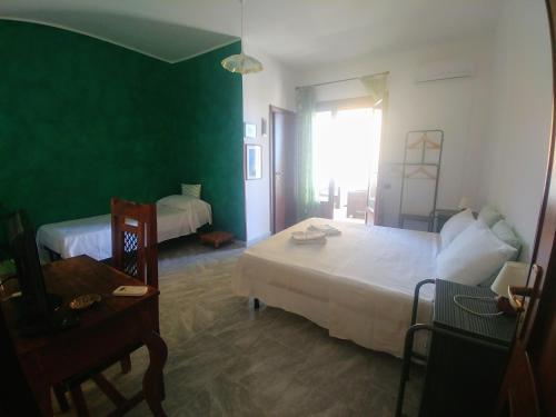 a bedroom with two beds and a table and a window at B&B Nereidi in Melito di Porto Salvo