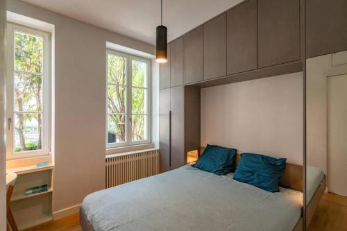 une chambre avec un grand lit avec des oreillers bleus dans l'établissement Côte des Basques, terrasse, confort et qualité, à Biarritz