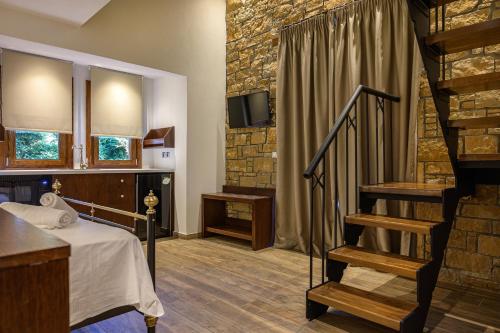 a room with a bed and a staircase with a tv at Arxontariki Suites in Ouranoupoli