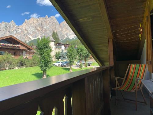 a balcony with a chair and a view of the mountains at Attico Vista Tofane in Cortina dʼAmpezzo
