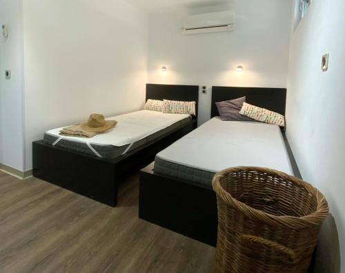 two twin beds in a room with a basket at Bastide de l'Olivaie in Bandol