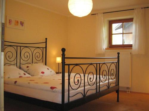 a bedroom with a black bed with pillows and a window at Ferienwohnung Aicher Sagberg in Frasdorf