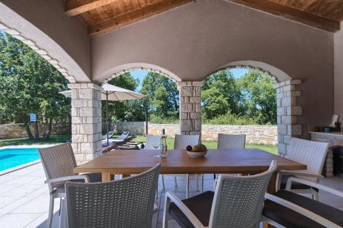an outdoor patio with a wooden table and chairs at Villa Krmed in Krmed